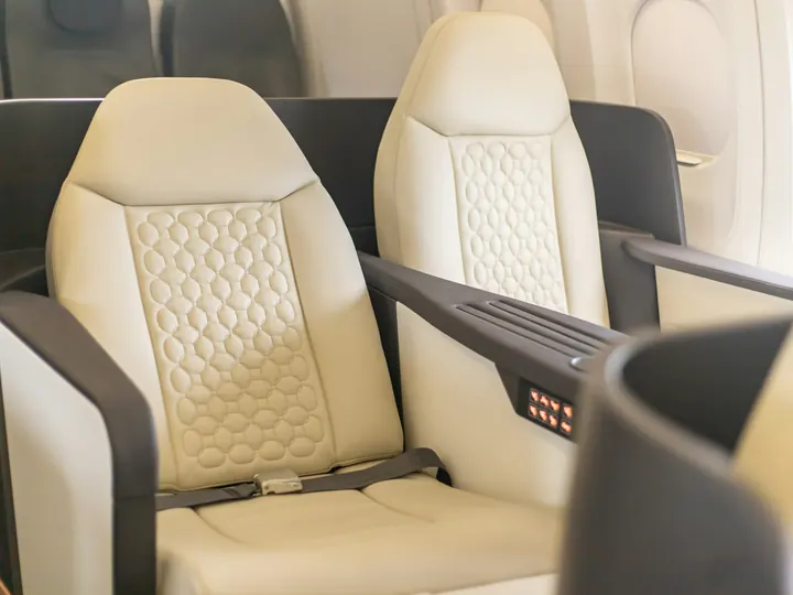 Cream leather seats facing each other in a light jet cabin