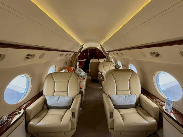 A warm-lit cabin with wide leather armchairs and a polished side ledge