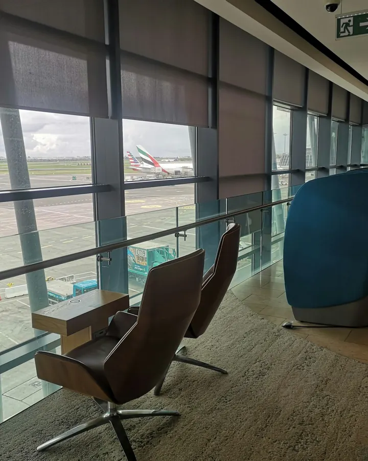 A quiet terminal lounge with tall windows looking onto the apron